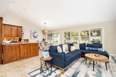 a living room with furniture a rug and a kitchen view
