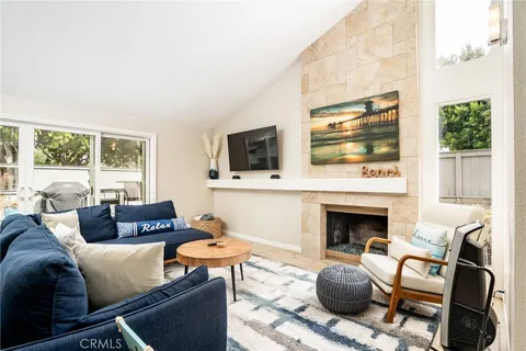 a living room with furniture a flat screen tv and a fireplace