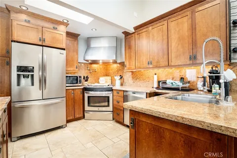 a kitchen with granite countertop a refrigerator stove and sink