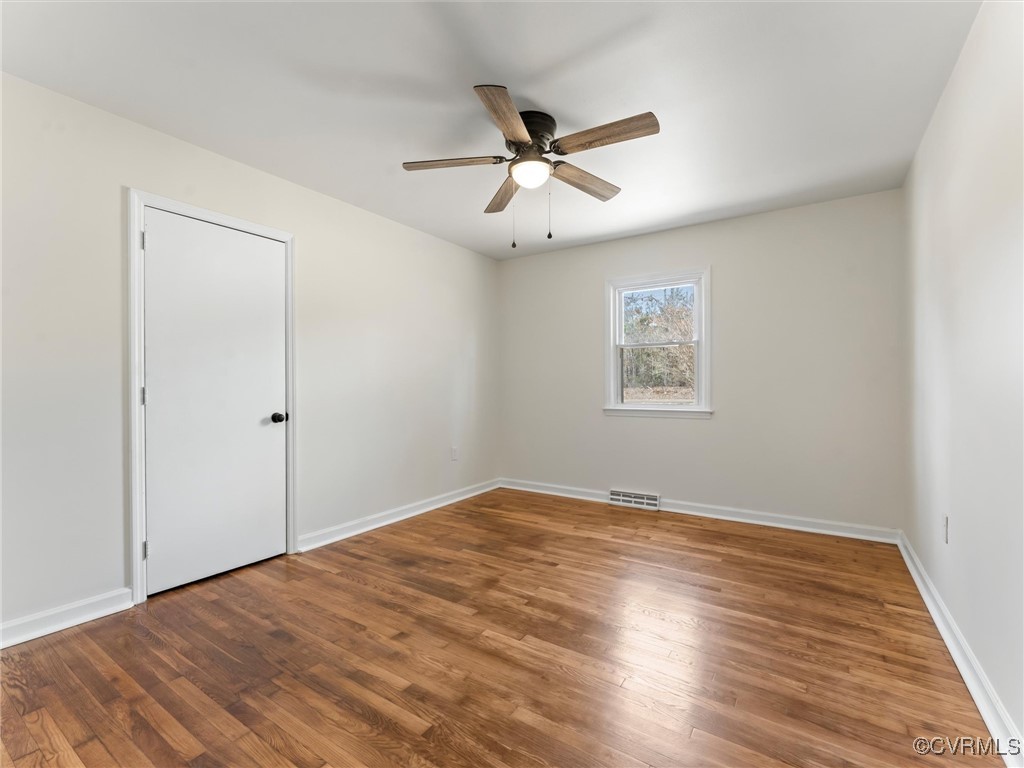 5521 Richmond Road Amelia Court House, VA 23002 - Photo 29 of 49 an empty room with wooden floor ceiling fan and windows