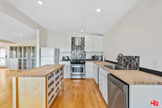 a kitchen with granite countertop a sink stove and refrigerator