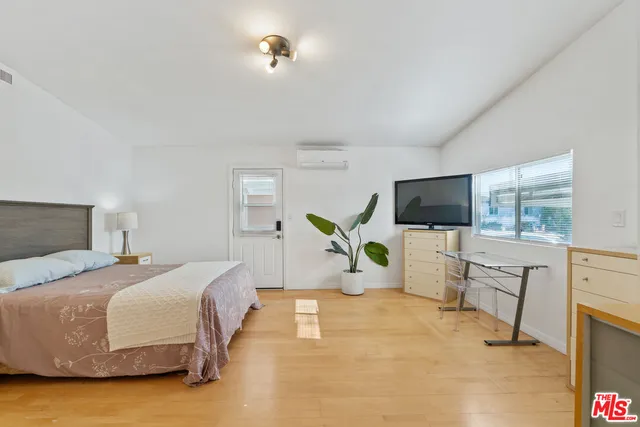 a bedroom with a bed and flat screen tv