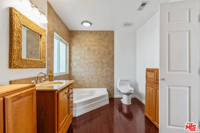 a bathroom with a granite countertop sink a toilet and a bathtub