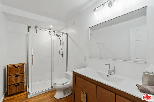 a bathroom with a granite countertop sink toilet and shower