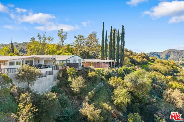 a view of a house with a garden and trees