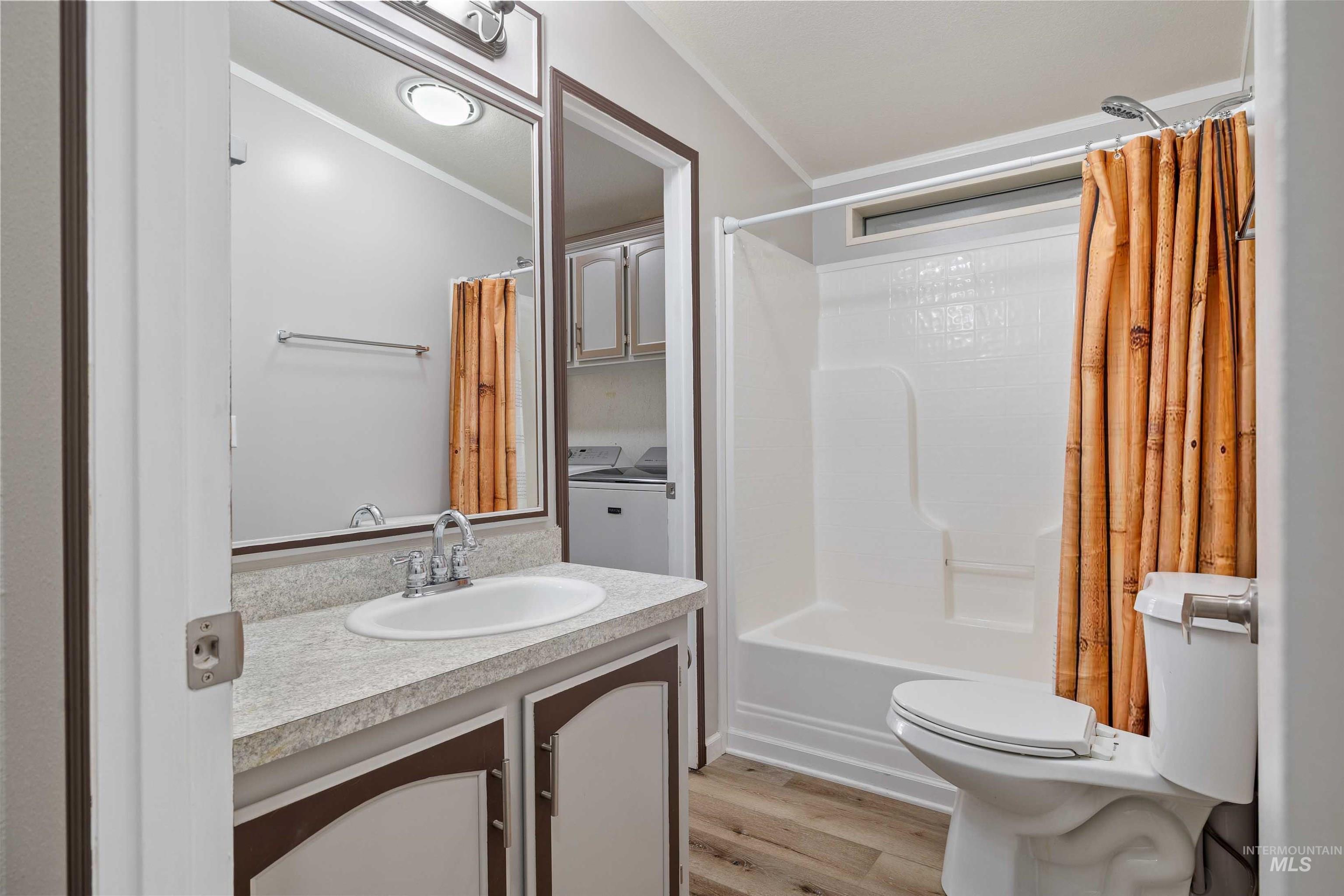 910 Moonglo, Unit 80 Buhl, ID 83316 - Photo 18 of 25 Full bathroom featuring a single vanity with an integrated sink, a combination shower and tub, and wood-finish flooring
