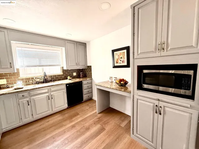 a kitchen with stainless steel appliances white cabinets a sink and a stove
