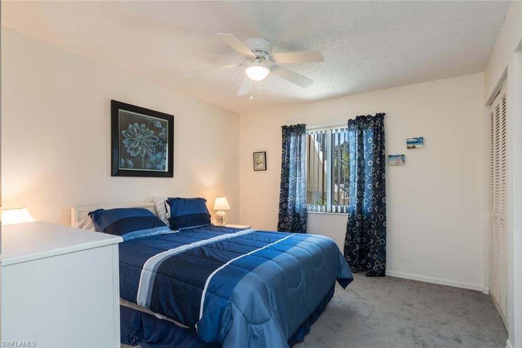 4973 Pepper Circle, Unit F105 Naples, FL 34113 - Photo 16 of 20 a bedroom with bed and a large mirror