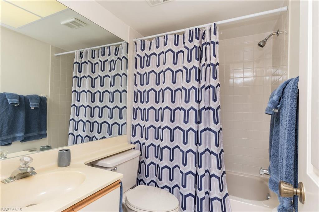 4973 Pepper Circle, Unit F105 Naples, FL 34113 - Photo 17 of 20 a bathroom with a sink toilet and shower