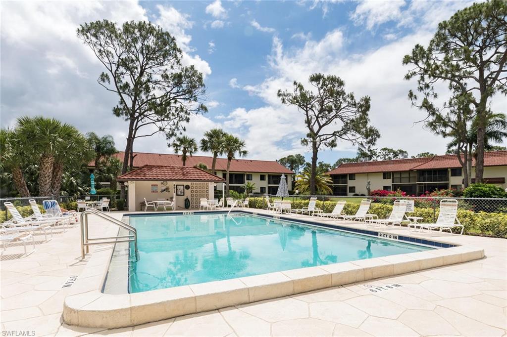 4973 Pepper Circle, Unit F105 Naples, FL 34113 - Photo 20 of 20 a view of a swimming pool with outdoor seating
