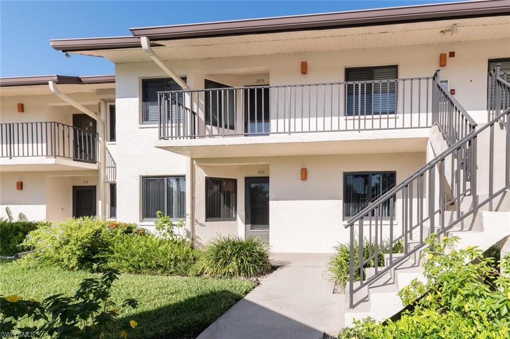 4973 Pepper Circle, Unit F105 Naples, FL 34113 - Photo 2 of 20 front view of a house with a porch