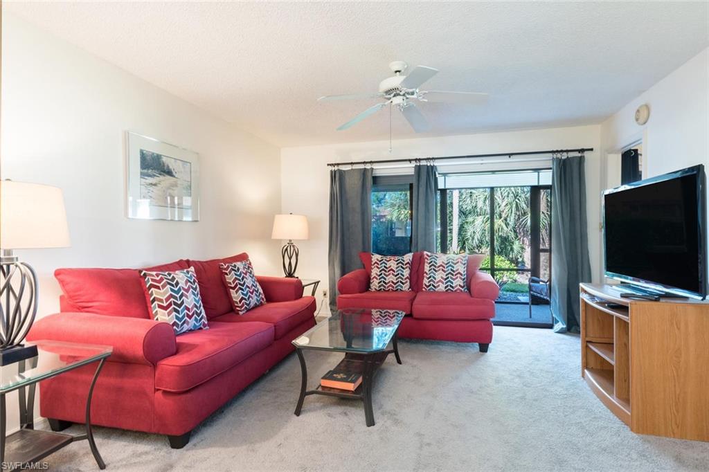 4973 Pepper Circle, Unit F105 Naples, FL 34113 - Photo 4 of 20 a living room with furniture and a flat screen tv