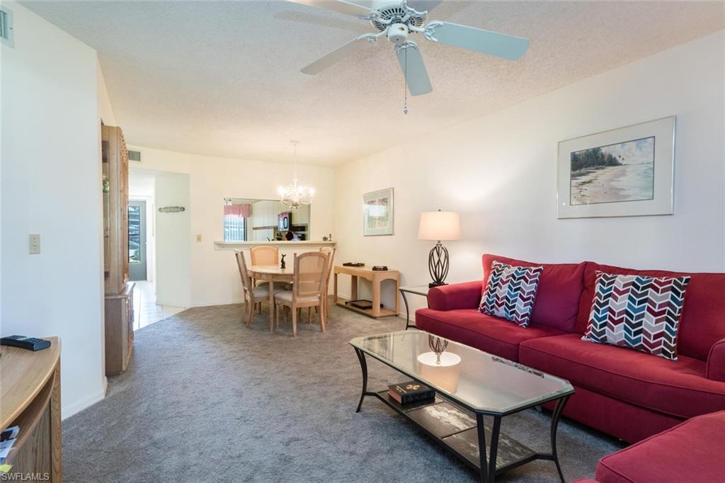 4973 Pepper Circle, Unit F105 Naples, FL 34113 - Photo 5 of 20 a living room with furniture and a view of kitchen