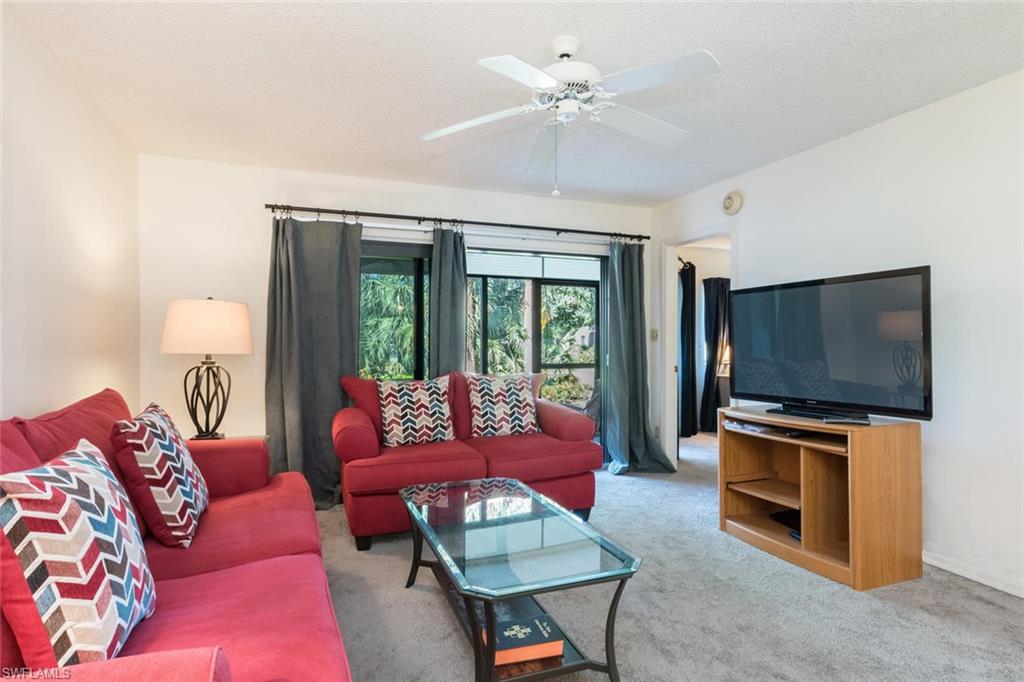 4973 Pepper Circle, Unit F105 Naples, FL 34113 - Photo 6 of 20 a living room with furniture and a flat screen tv