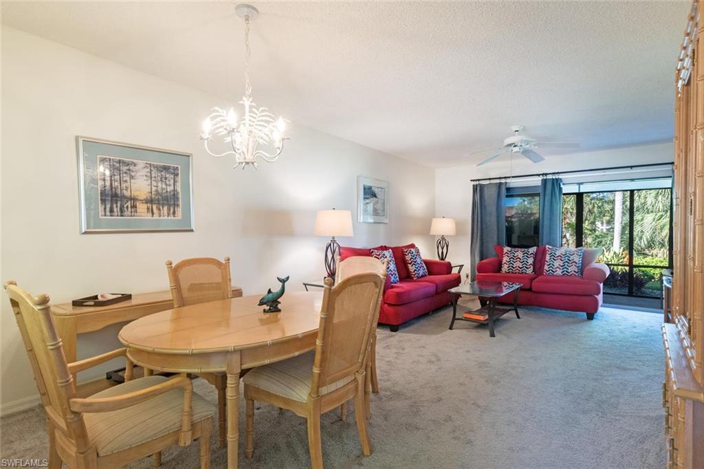 4973 Pepper Circle, Unit F105 Naples, FL 34113 - Photo 7 of 20 a living room with dining table and a chandelier