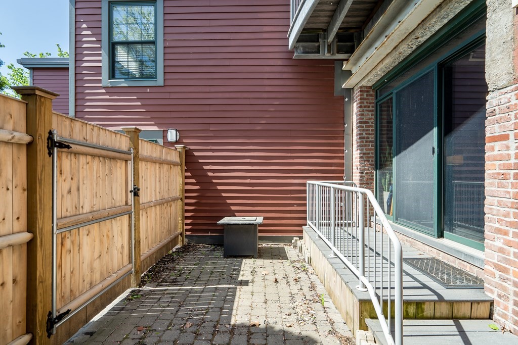 210 Broadway, Unit 103 Everett, MA 02149 - Photo 16 of 16 a view of a patio with a table and chairs and wooden floor