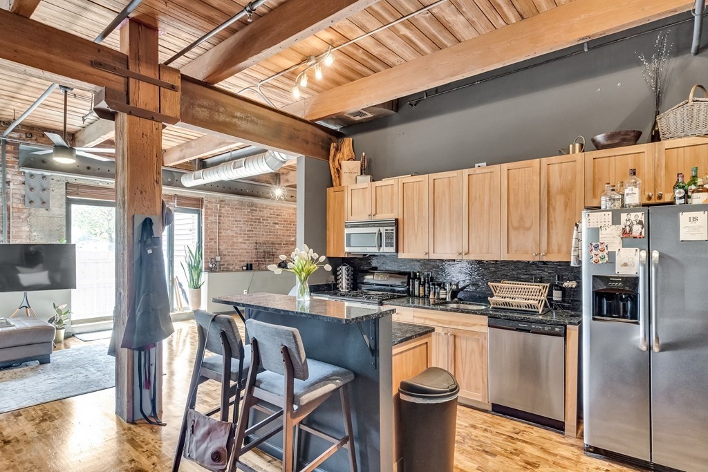 210 Broadway, Unit 103 Everett, MA 02149 - Photo 6 of 16 a kitchen with a stove a sink and a refrigerator