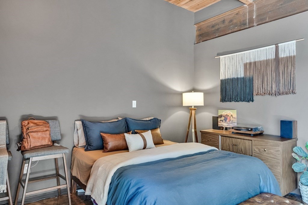 210 Broadway, Unit 103 Everett, MA 02149 - Photo 8 of 16 a bedroom with a bed and a lamp on table