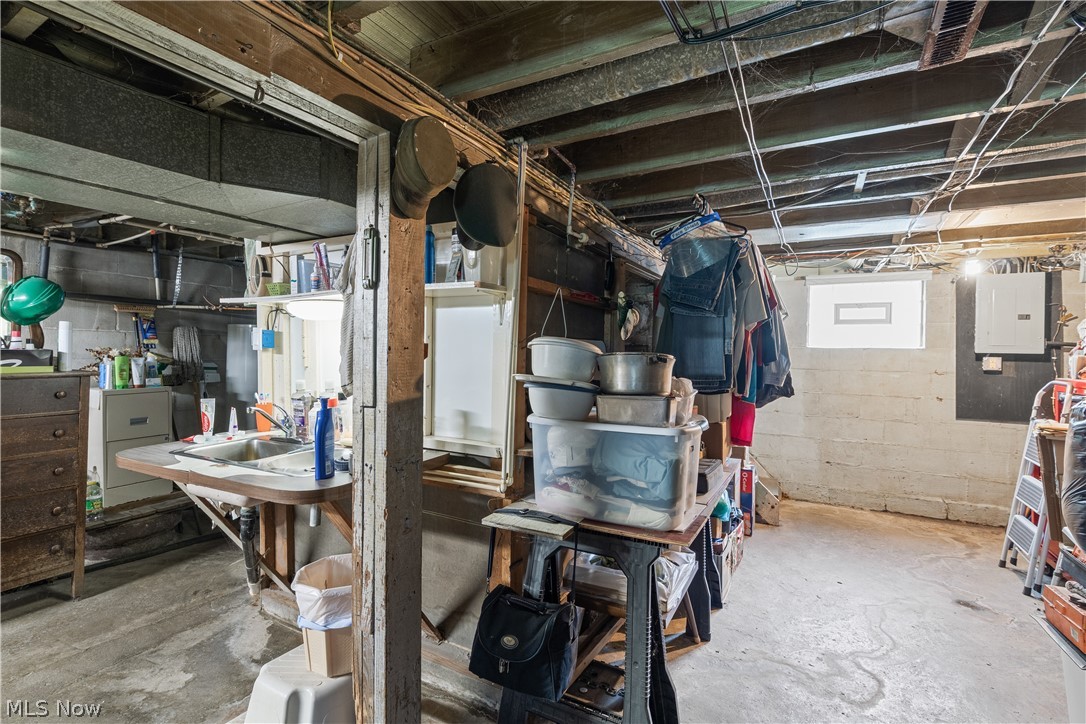 6324 Struthers Road Youngstown, OH 44514 - Photo 42 of 42 Lower level utility area featuring an exposed beam ceiling, concrete flooring, a utility sink, and wall-mounted electrical panels