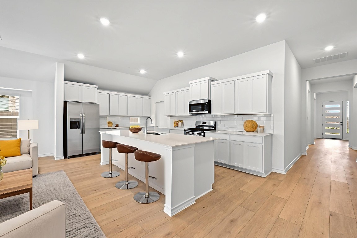 1613 Dove Rnch Road Georgetown, TX 78628 - Photo 4 of 29 a kitchen with white cabinets and stainless steel appliances