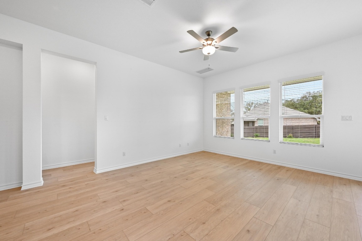 1613 Dove Rnch Road Georgetown, TX 78628 - Photo 6 of 29 a view of an empty room with a window and wooden floor