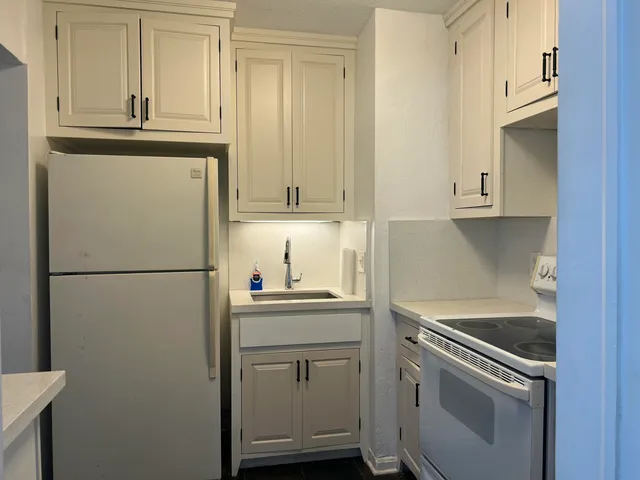 a white refrigerator freezer sitting inside of a kitchen