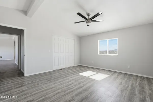 a view of a big room with wooden floor closet and windows