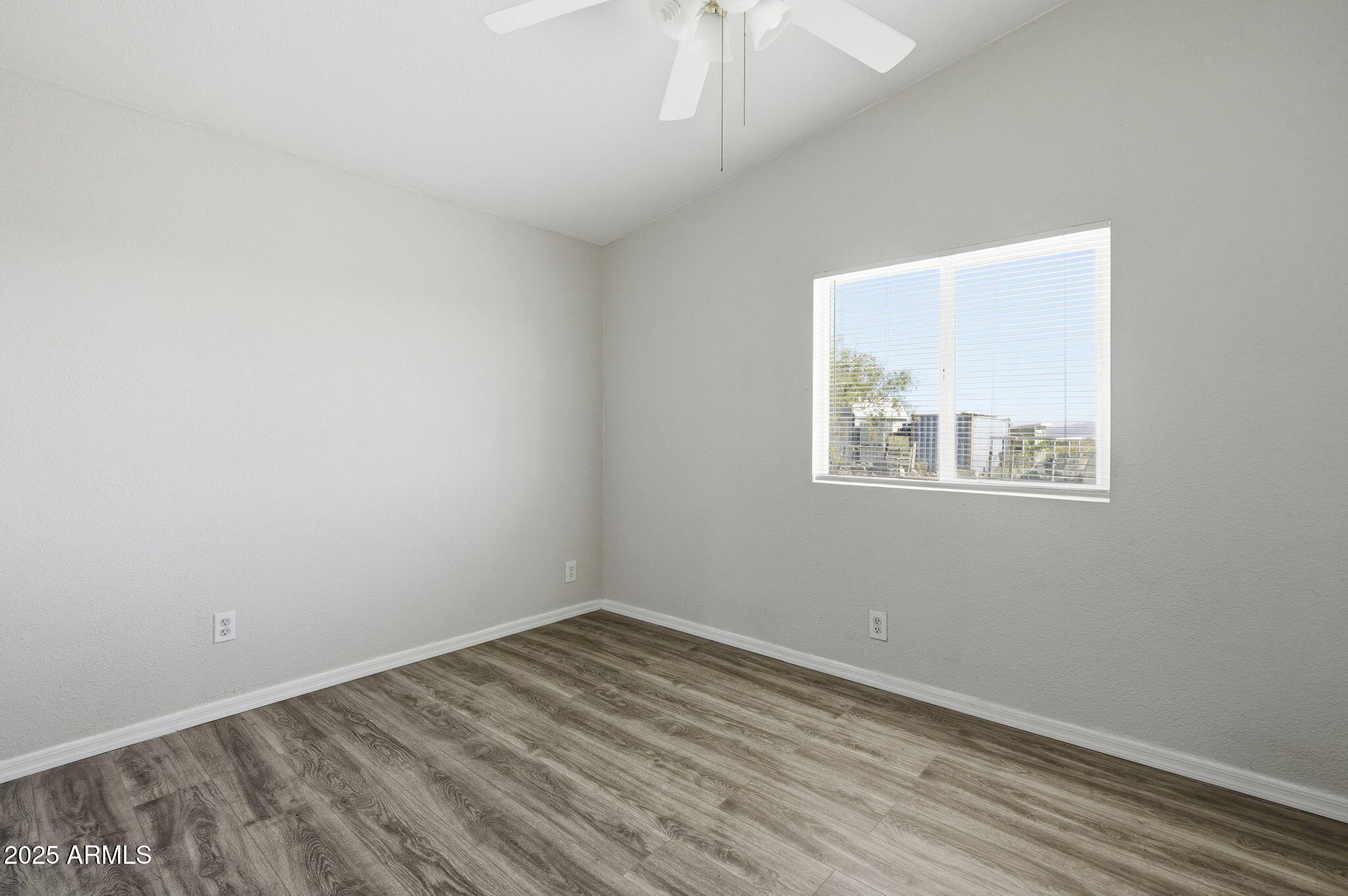 25100 East Lori Road Benson, AZ 85602 - Photo 18 of 30 an empty room with wooden floor and windows