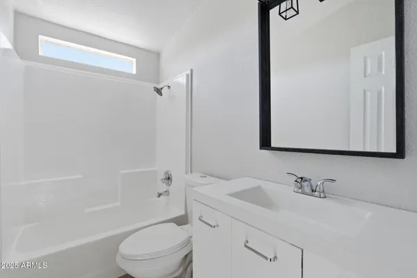 a bathroom with a granite countertop sink a toilet and shower