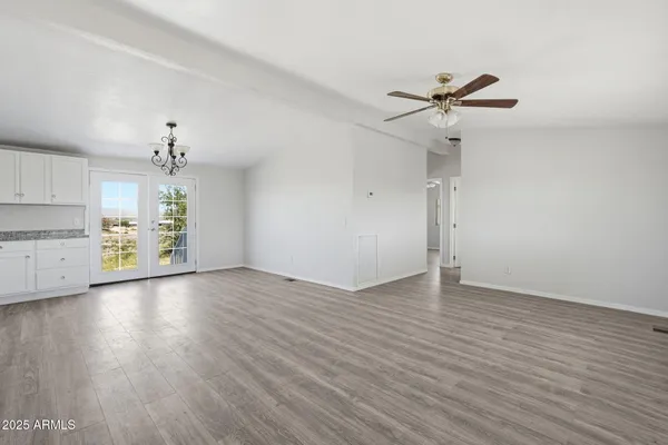 a view of a kitchen with a dishwasher a kitchen island hardwood floor and a sink