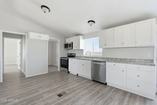 a kitchen with granite countertop white cabinets and white appliances