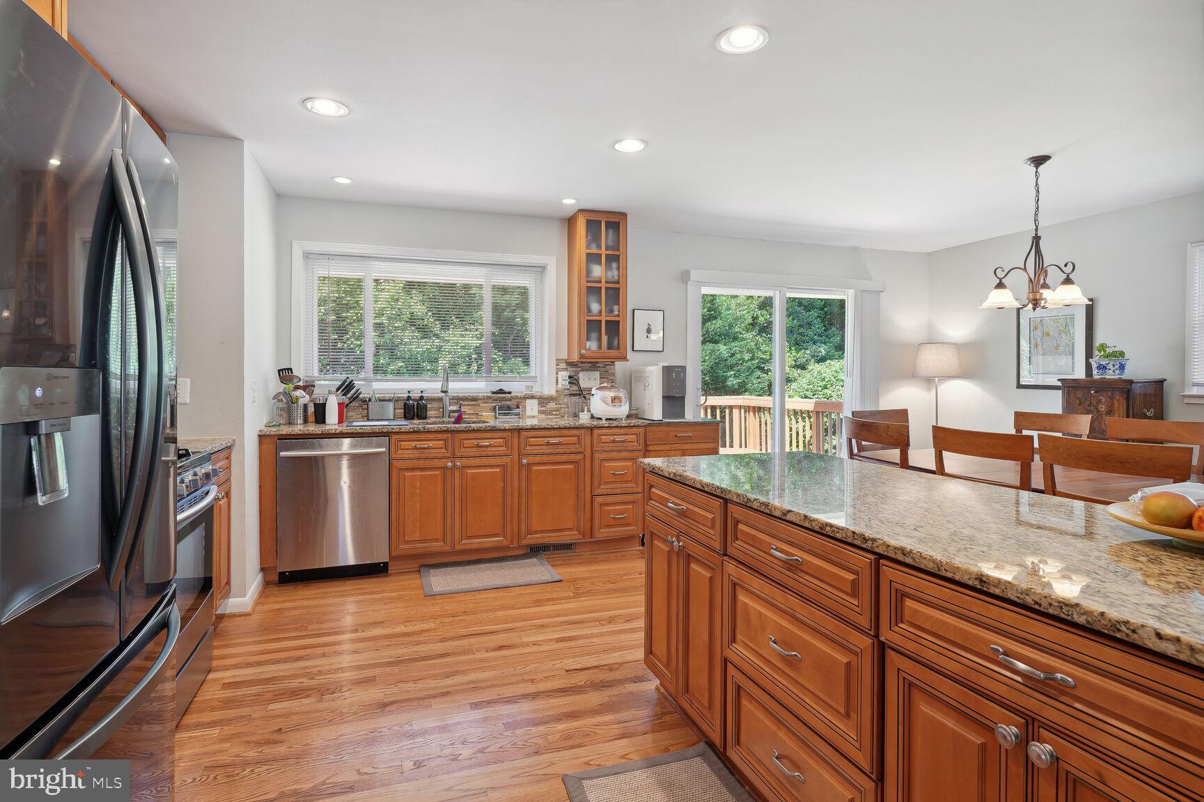 7011 Hector Road McLean, VA 22101 - Photo 2 of 20 a kitchen with granite countertop a window a sink stainless steel appliances and windows