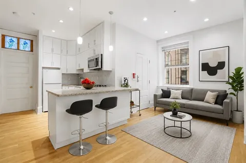 a living room with furniture and a kitchen view