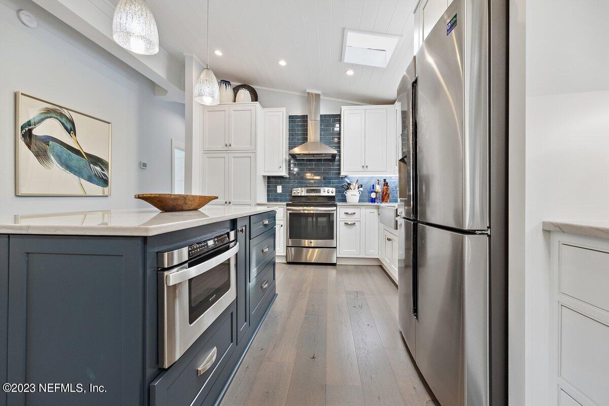 1320 4th Street Neptune Beach, FL 32266 - Photo 9 of 30 a kitchen with stainless steel appliances a stove a refrigerator and a sink