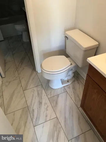 a white toilet sitting next to a shower
