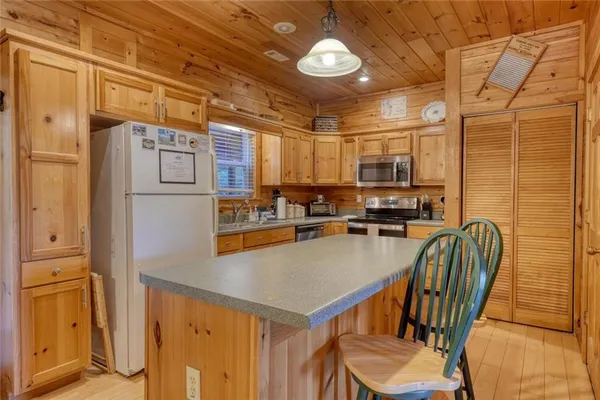 a kitchen with stainless steel appliances kitchen island granite countertop a stove a sink and a refrigerator