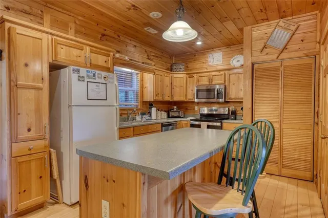 a kitchen with stainless steel appliances kitchen island granite countertop a stove a sink and a refrigerator