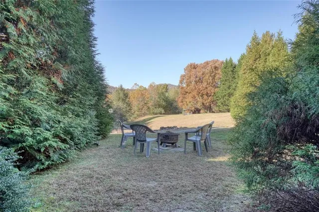 a view of a roof deck with table and chairs a barbeque with wooden floor