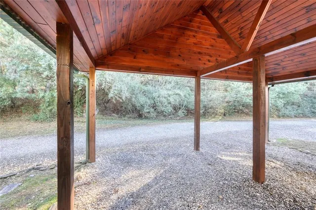 a view of a yard with plants and trees in front of it