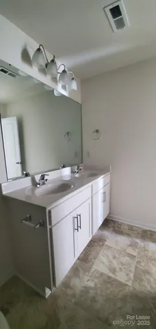 a bathroom with a double vanity sink and mirror
