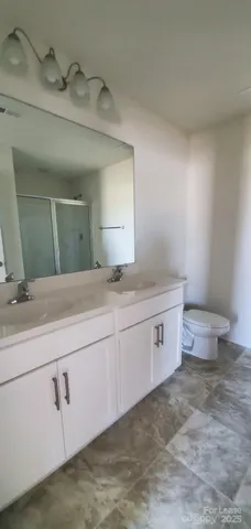 a spacious bathroom with a granite countertop sink a toilet and mirror