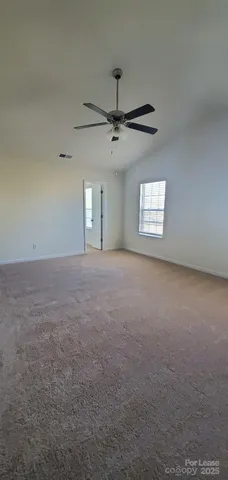a view of a big room with windows and chandelier fan