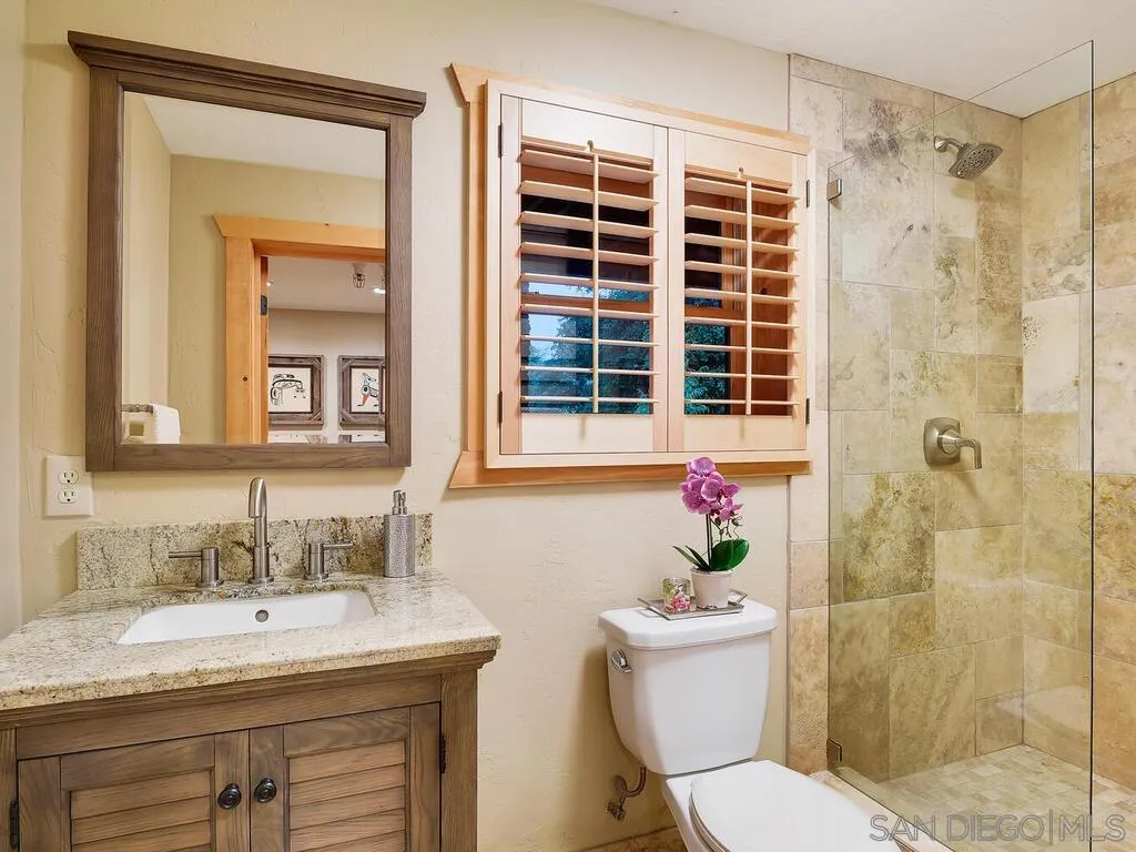 1068 West Incense Cedar Road Julian, CA 92036 - Photo 47 of 63 a bathroom with a granite countertop sink toilet mirror and shower