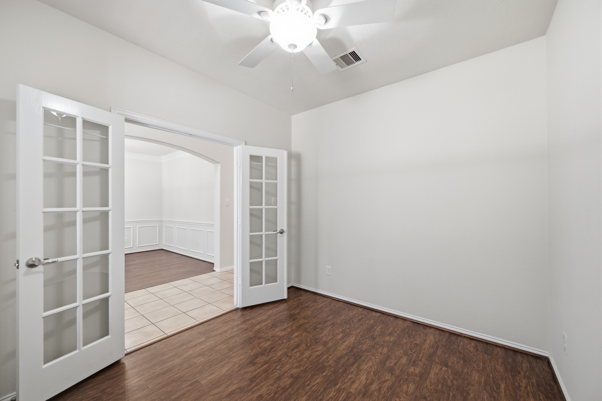 2117 Rushing Spring Drive Pearland, TX 77584 - Photo 8 of 42 Elevate your work-from-home experience in this bright office/study, featuring elegant French doors and rich flooring for a perfect blend of style and functionality.