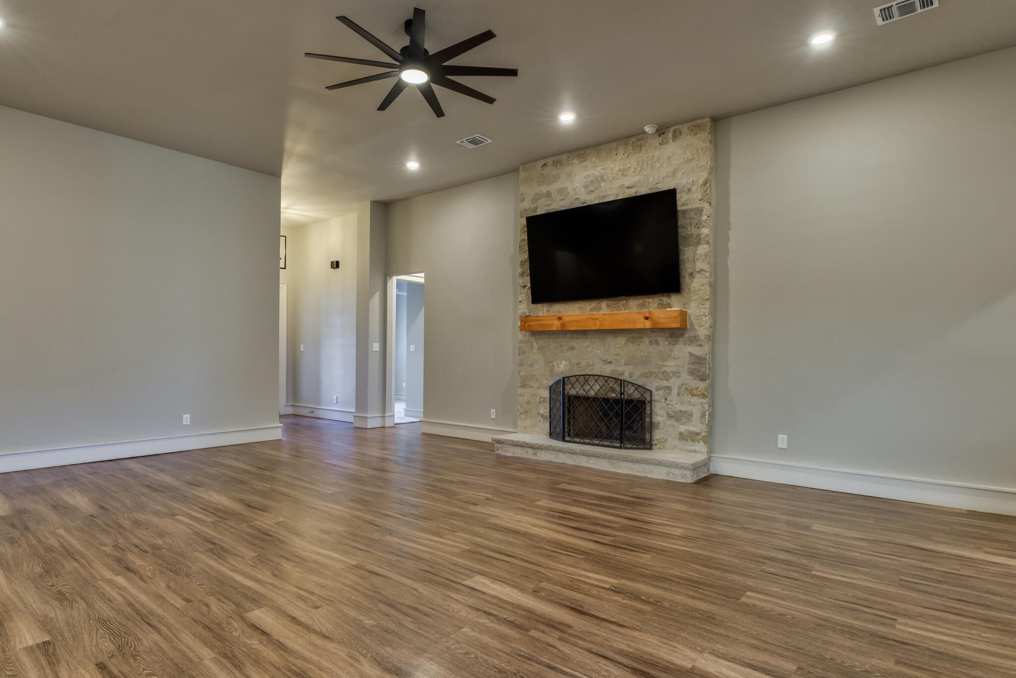 5303 110th Street Lubbock, TX 79424 - Photo 13 of 55 a view of a livingroom with a fireplace a ceiling fan and staircase