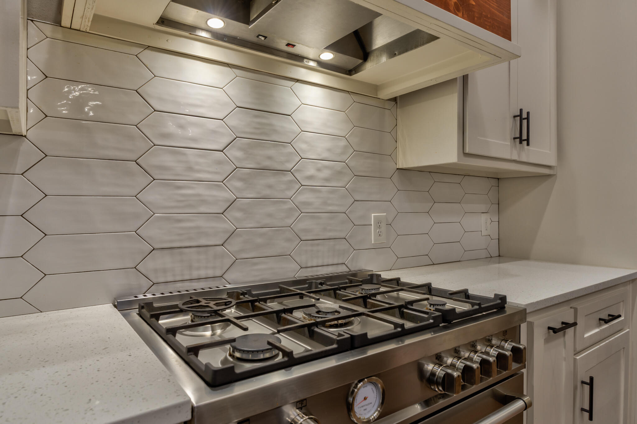 5303 110th Street Lubbock, TX 79424 - Photo 23 of 55 a stove sitting inside of a kitchen with white cabinets