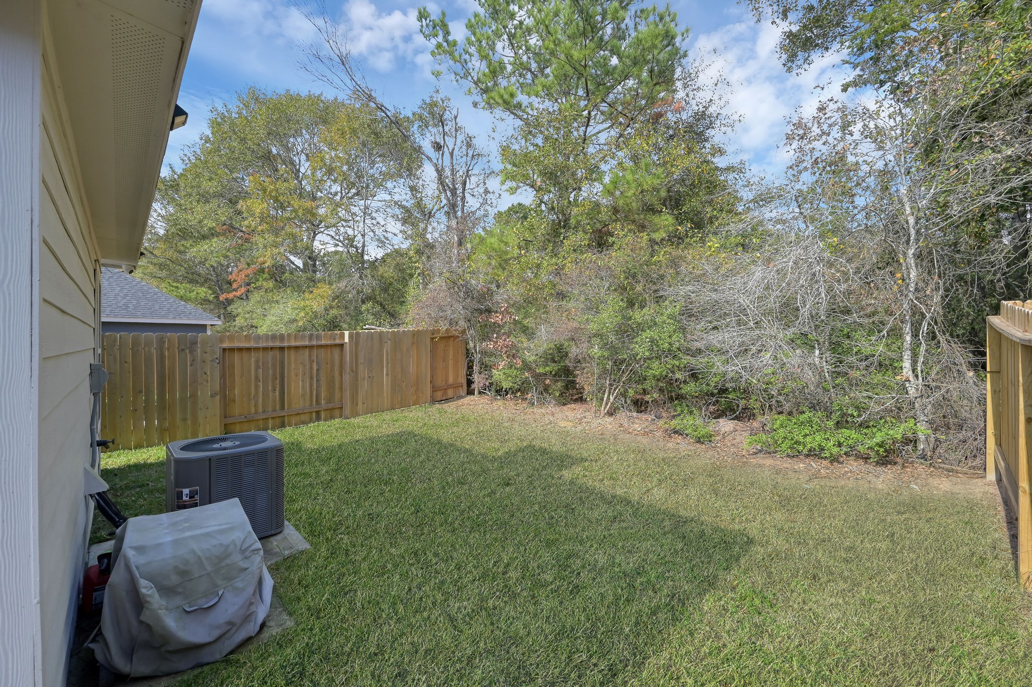 16399 Jasmine Marie Place Conroe, TX 77306 - Photo 16 of 22 a view of a backyard with table and chairs and wooden fence