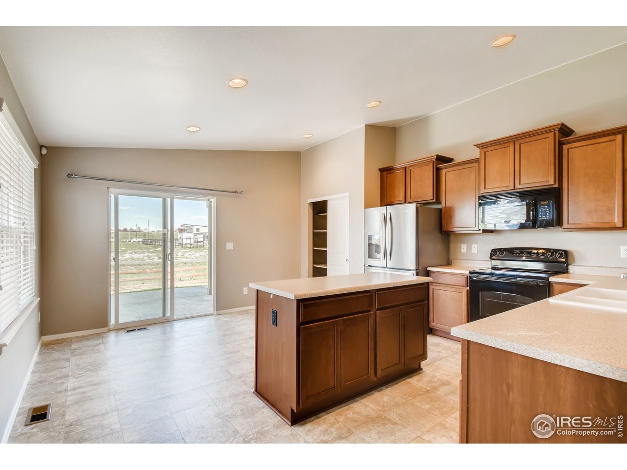 8663 Raspberry Drive Frederick, CO 80504 - Photo 6 of 33 a kitchen with stainless steel appliances granite countertop a stove top oven a sink dishwasher and a refrigerator with wooden floor