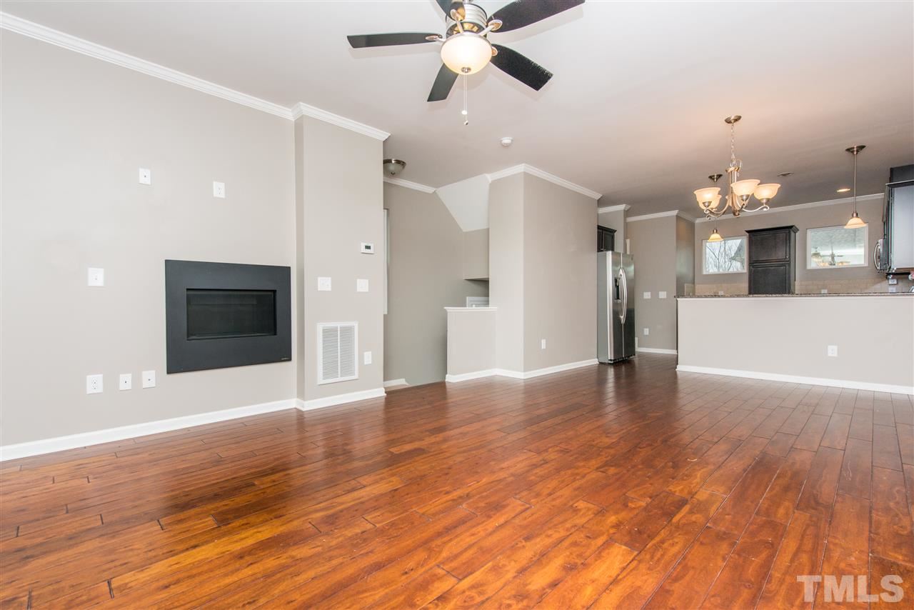 1433 Crafton Way Raleigh, NC 27607 - Photo 23 of 23 an empty room with wooden floor and a kitchen