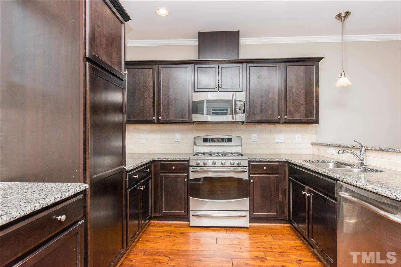 1433 Crafton Way Raleigh, NC 27607 - Photo 7 of 23 a kitchen with kitchen island granite countertop a sink stove and refrigerator